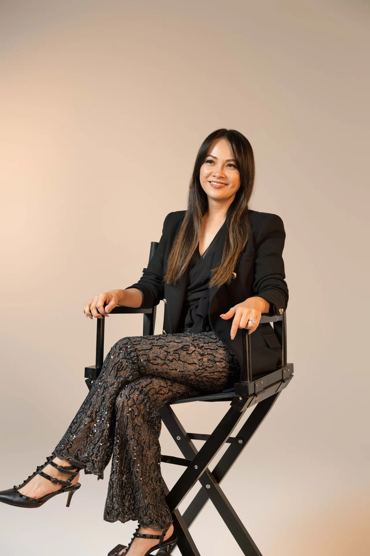 Makeup artist and educator Hong Le seated in a director’s chair